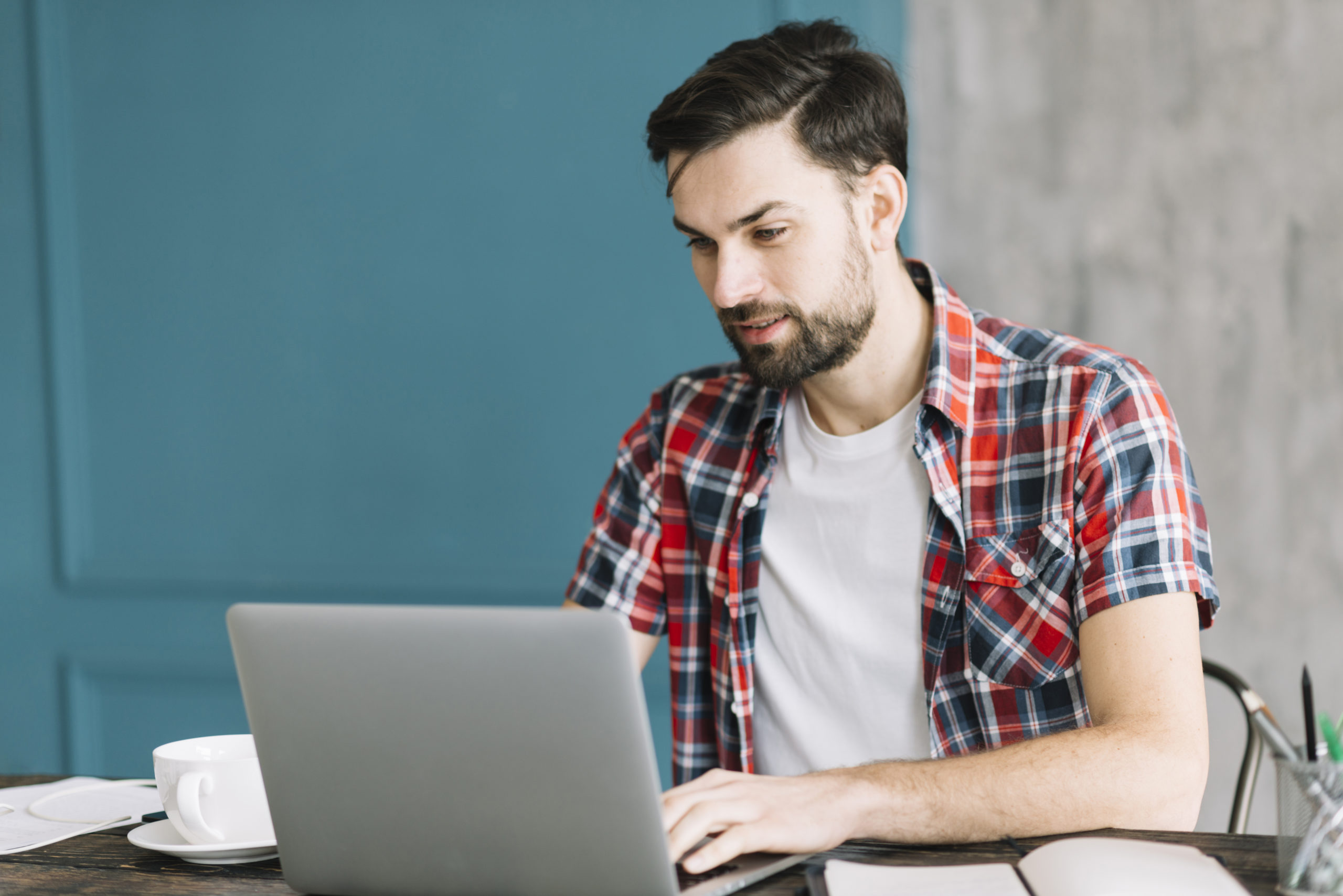 hombre con laptop sentado en una mesa